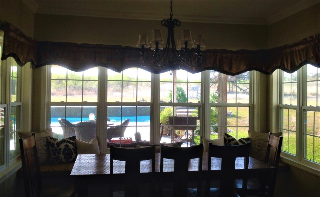 Before picture of breakfast nook with 5 ready-made valances use to cover the expanse of windows.